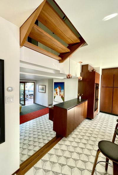 Kitchen remodel with geometric tile floor, custom wood cabinetry, and built-in appliances